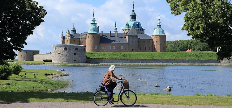Kvinna som cyklar, Kalmar Slott som bakgrund